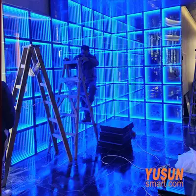 On-site installation of blue LED modular infinity mirror wall tiles, technician mounting YUSUN SMART abyss mirror panels